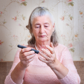 Older person self administering a blood test