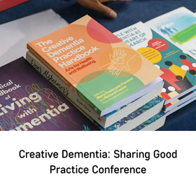 Pile of colorful dementia care books, including 'Creative Dementia: Sharing Good Practice Handbook' on top.