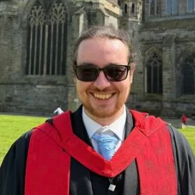 Smiling man wearing sunglasses on teal background, with Dementia Researcher logo and 'Dr Connor McDonald' badge.