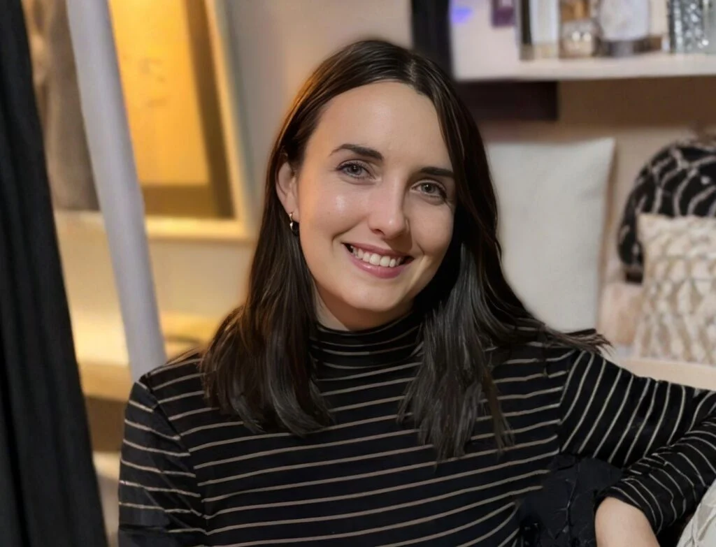 Dr Kira Shaw smiling, wearing a dark striped top.
