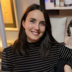Dr Kira Shaw smiling, wearing a dark striped top.